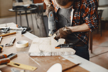 Wood cutting with circular saw. Closeup of mature man sawing lumber.