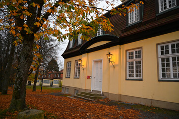 A baroque villa with  lamps shining on the facade. The pedestrian way in front of the house is...