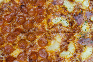 Top view of pizza background with sliced pepperoni , Pineapples , Parma ham. Pizza background half pepperoni and hawaiian.