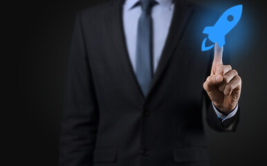 Startup business concept, Businessman holding tablet and icon rocket is launching and soar flying out from screen with network connection on dark background.