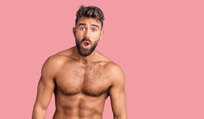 Fototapeta premium Young hispanic man wearing swimwear shirtless afraid and shocked with surprise expression, fear and excited face.