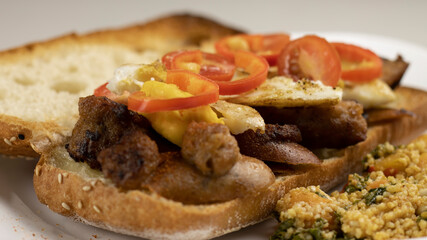 Grilled Sausage Meat on Italian Ciabatta Bread with eggs, tomato and red pepper. Selective focus.