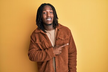 African american man with braids wearing brown retro jacket pointing aside worried and nervous with...
