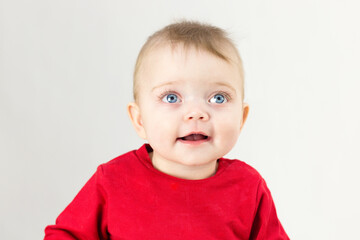 Six month old baby with big eyes and a beautiful smile on white background.