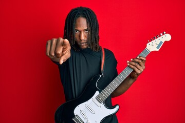 African american man with braids playing electric guitar pointing with finger to the camera and to...