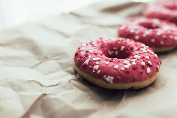 Fresh raspberry donuts on crumpled craft paper