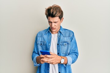 Handsome caucasian man using smartphone skeptic and nervous, frowning upset because of problem. negative person.