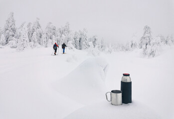 Hot coffee break in snowy, frosty, icy winter forest in Harz Mountains (Brocken). Germany. Thermos...
