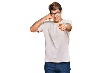 Handsome caucasian man wearing casual clothes and glasses smiling doing talking on the telephone...