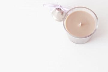 Fototapeta na wymiar brown candle with small silver bell on white background