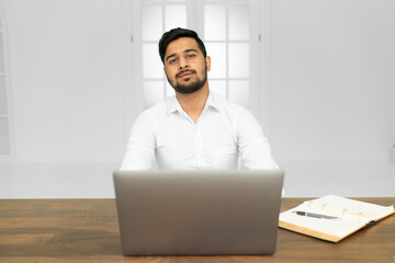 Portrait of confident indian business agent with laptop typing email feel positive