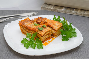 Beef lasagna served with fresh parsley close up on plate