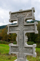 monument to the catholic cross in the mountains against the backdrop of the autumn forest