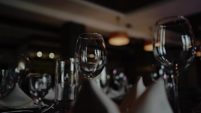 Transparent glasses and plates on a banquet table. Night Party at a fancy restaurant. Festive time, celebration event on holidays. Table setting.
