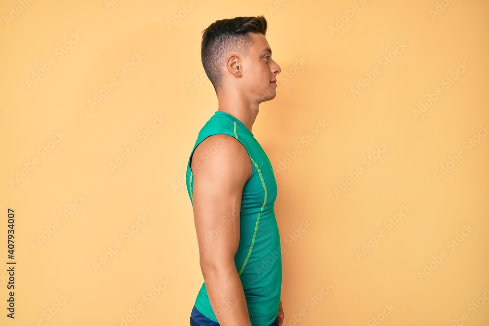 Wall mural Young hispanic boy wearing sporty style with sleeveless shirt looking to side, relax profile pose with natural face with confident smile. - Wall murals