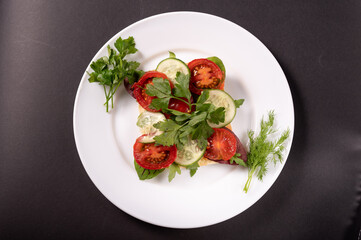 Vegetables and herbs on a white plate. Salad in a white plate. Top.