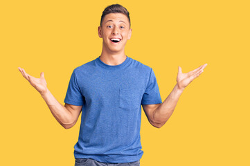 Young handsome hispanic man wearing casual clothes celebrating victory with happy smile and winner expression with raised hands