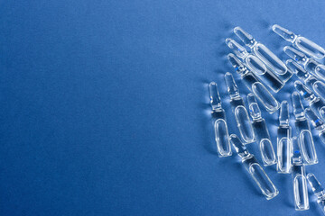 Medical ampoules with vaccine on a blue background.