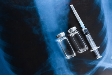 Fototapeta na wymiar Vaccine against the virus. Two ampoules with medicine and a syringe for fluorography.