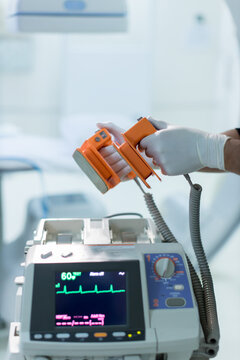 The doctor is giving a defibrillators to save the patient's life in the hospital. 