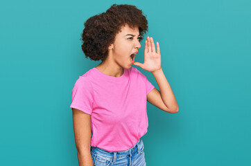 Young hispanic girl wearing casual clothes shouting and screaming loud to side with hand on mouth. communication concept.