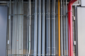 Obraz premium Ventilation system and pipe systems installed on industrial building. Electrical conduits system and metal pipeline installed on building.