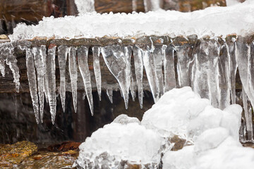 Beautiful icicles on a frozen mountain stream. Winter mountain landscape