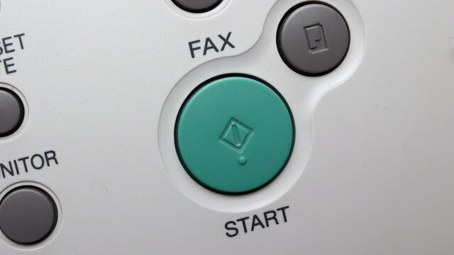 Male Finger Presses The Start Button On White Fax
