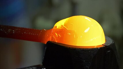 Glass handmade production, golden ball of hot glass.