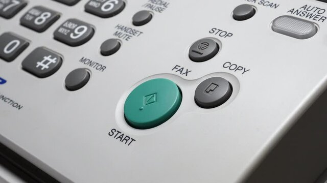 Male Finger Presses The Start Button On White Fax.