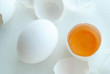 Chicken eggs in a tray on a white background, broken egg, white and yolk.