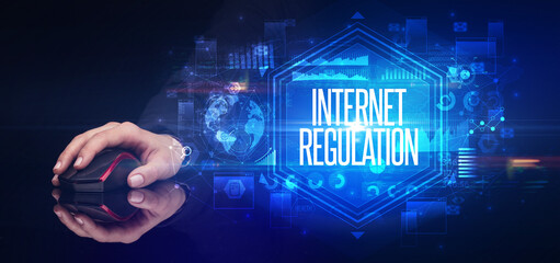 hand holding wireless peripheral with INTERNET REGULATION inscription, cyber security concept