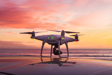 Naklejka na ściany i meble Drone al atardecer sobre auto en la playa