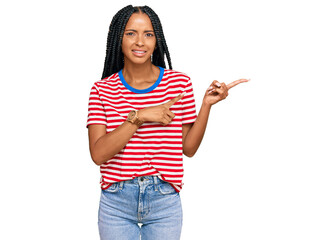 Beautiful hispanic woman wearing casual clothes pointing aside worried and nervous with both hands,...