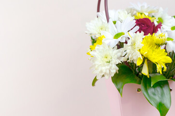 Bouquet of flowers in a paper pink basket with place for text