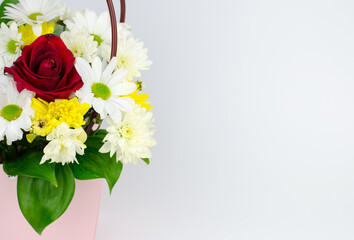 Bouquet of flowers in a paper pink basket with place for text