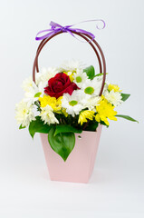 Fototapeta na wymiar Bouquet of flowers in a paper basket on a white background