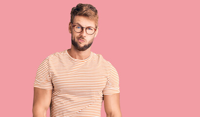 Young caucasian man wearing casual clothes and glasses looking sleepy and tired, exhausted for fatigue and hangover, lazy eyes in the morning.