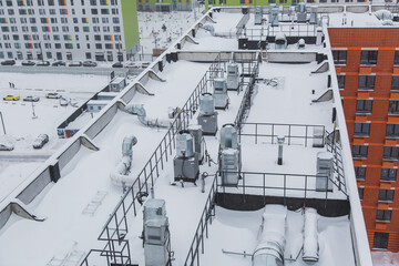 snow-covered roof with ventilation of a new high-rise apartment building 