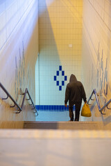 A Man Walking on stairs holding a bag 