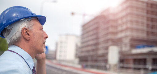 Architect talking on the cellphone in front of construction site