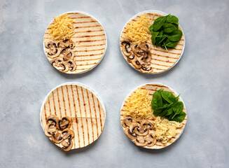 Obraz na płótnie Canvas Tortillas with different fillings of mushrooms, cheese, spinach and fried egg. Food trend. Step by step photo instruction.