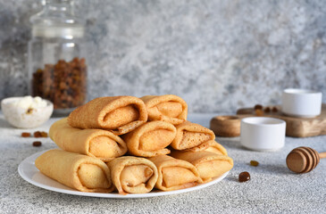 Thin spring rolls on a light concrete background. Platbands. National, traditional dish of Belarus and Ukraine. Pancakes