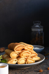 Thin pancakes with cottage cheese on a dark concrete background. Platbands. National, traditional dish of Belarus and Ukraine.