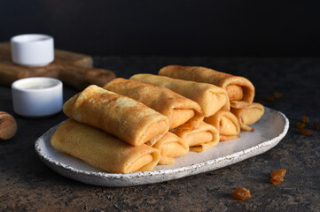 Thin pancakes with cottage cheese on a dark concrete background. Platbands. National, traditional dish of Belarus and Ukraine.