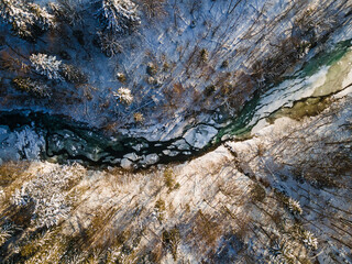 Frozen River Flowing Trough Forest. Bieszczady Mountains Park in Poland. Drone View. Winter Season