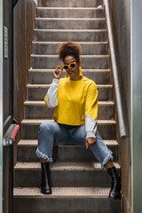 Fashionable ethnic hipster woman in yellow outfit