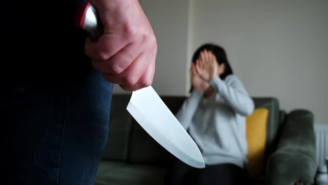 The man threatens the woman with a knife. Violence in family.