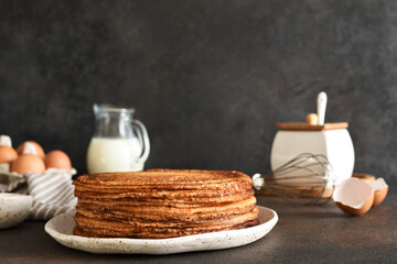 Stack of pancakes on the plate for breakfast. Pancake ingredients: milk, eggs, flour. Thin pancakes. Good morning.