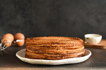 Stack of pancakes on the plate for breakfast. Pancake ingredients: milk, eggs, flour. Thin pancakes. Good morning.